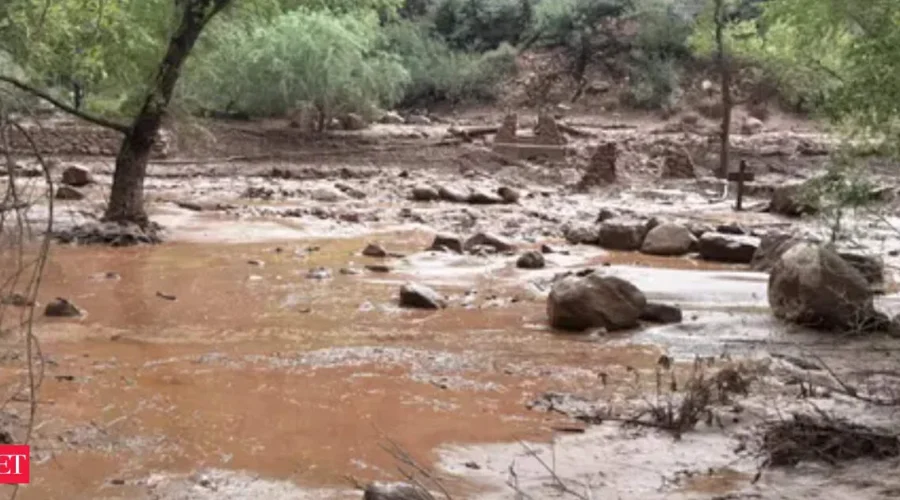 Floodwater flowing through a canyon area near the Grand Canyon with rescue crews nearby